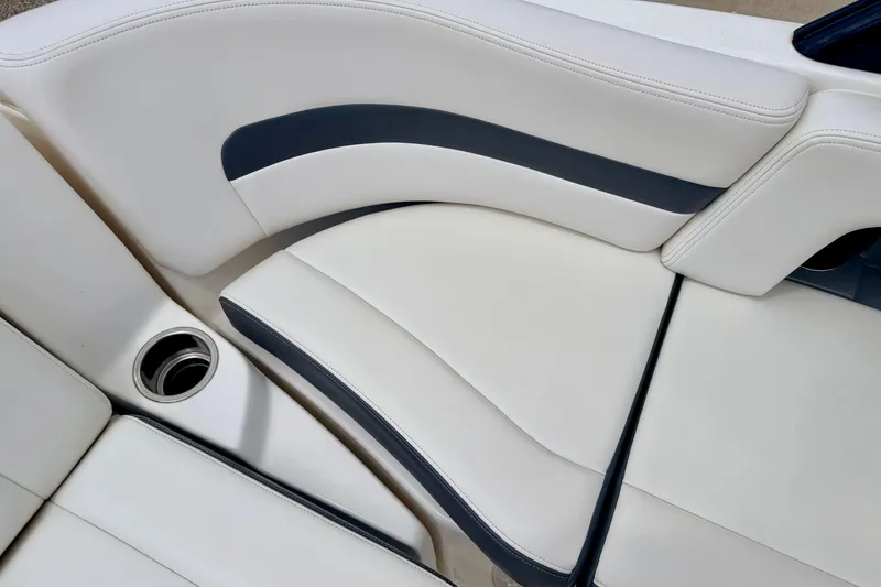 Slide: The Image of 2015 Chaparral Sunesta 264 boat interior with white and navy seating and cup holder. - 31