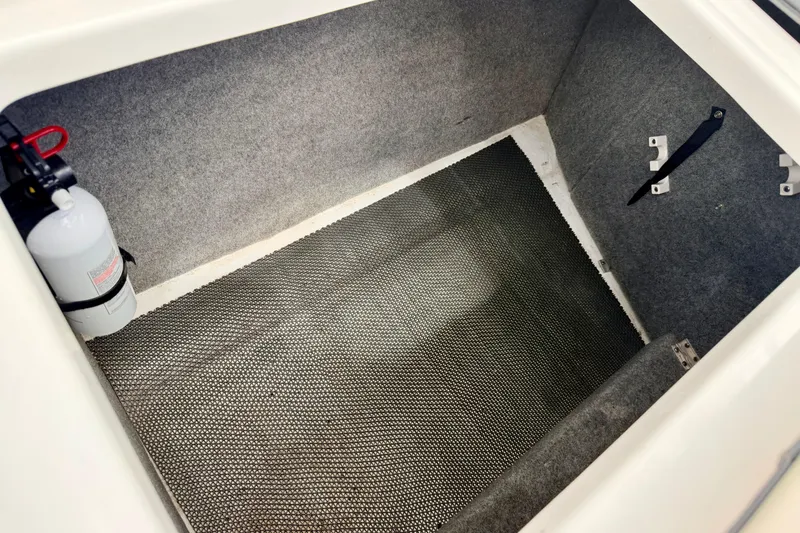 Slide: The Image of 2015 Chaparral Sunesta 264 storage compartment with fire extinguisher and carpeted interior. - 35