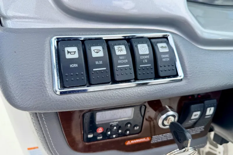 Slide: The Image of Control panel of a 2015 Chaparral Sunesta 264 boat with labeled switches and ignition. - 46
