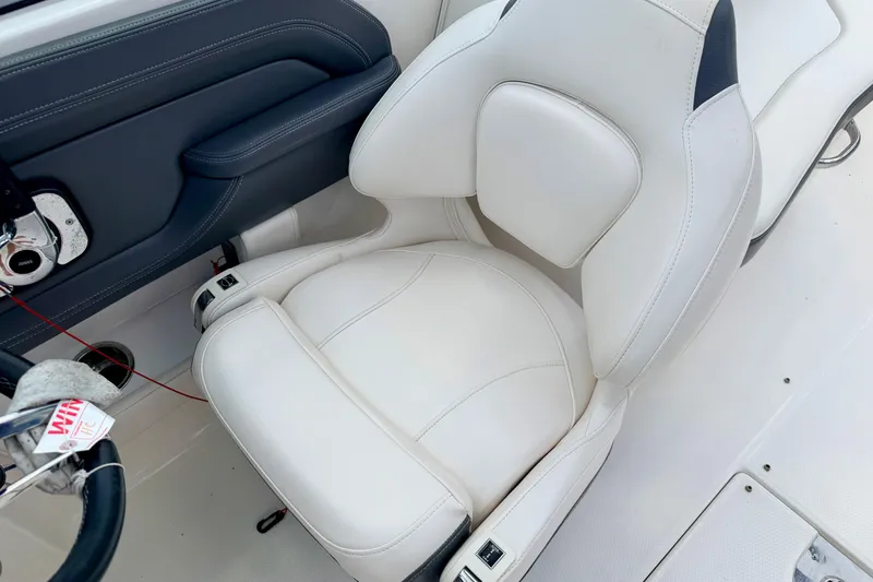 Slide: The Image of 2015 Chaparral Sunesta 264 boat interior with white cushioned seat and steering wheel. - 50