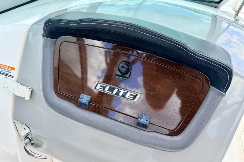 Slide: The Image of 2015 Chaparral Sunesta 264 boat dashboard with Elite emblem and wood finish. - 54