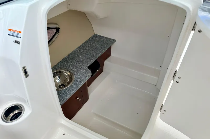 Slide: The Image of 2015 Chaparral Sunesta 264 boat interior with sink and storage area. - 57