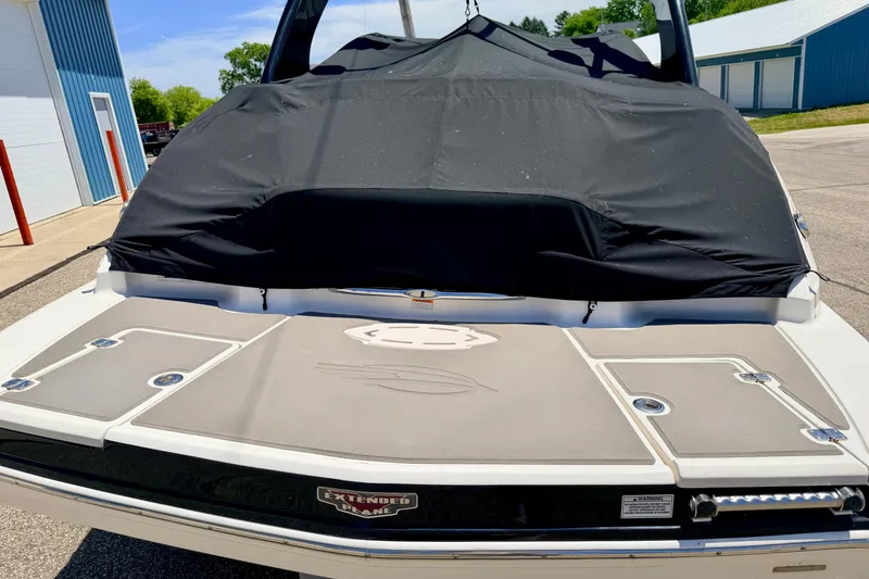 Slide: The Image of 2015 Chaparral Sunesta 264 boat with black cover, docked outdoors. - 59