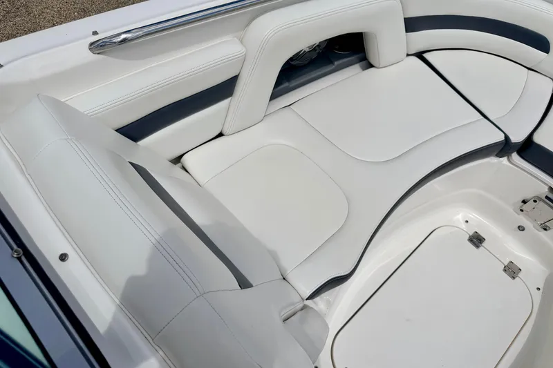 Slide: The Image of 2015 Chaparral Sunesta 264 boat interior with white cushioned seating and storage compartments. - 68