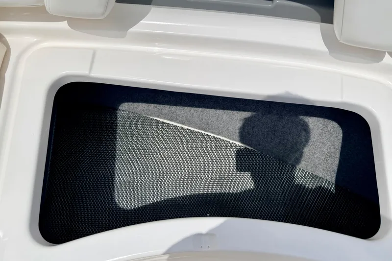Slide: The Image of Storage compartment on a 2015 Chaparral Sunesta 264 boat, featuring a mesh cover. - 70