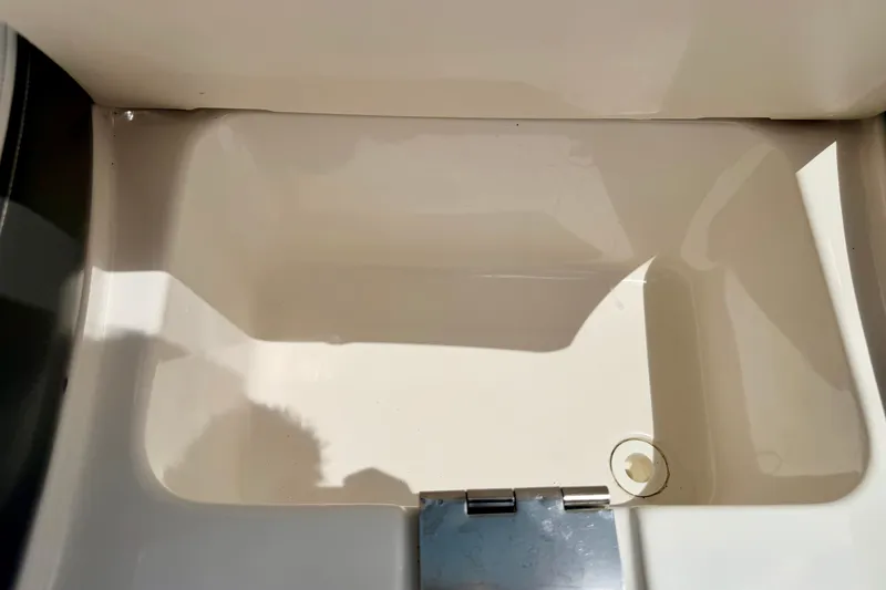 Slide: The Image of Interior compartment of 2015 Chaparral Sunesta 264 boat, featuring a clean, white finish. - 74
