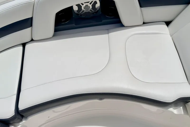 Slide: The Image of 2015 Chaparral Sunesta 264 boat interior with white cushioned seating and speaker detail. - 76