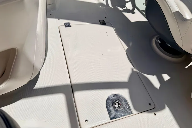 Slide: The Image of 2015 Chaparral Sunesta 264 boat interior, featuring a storage compartment and seating area. - 99