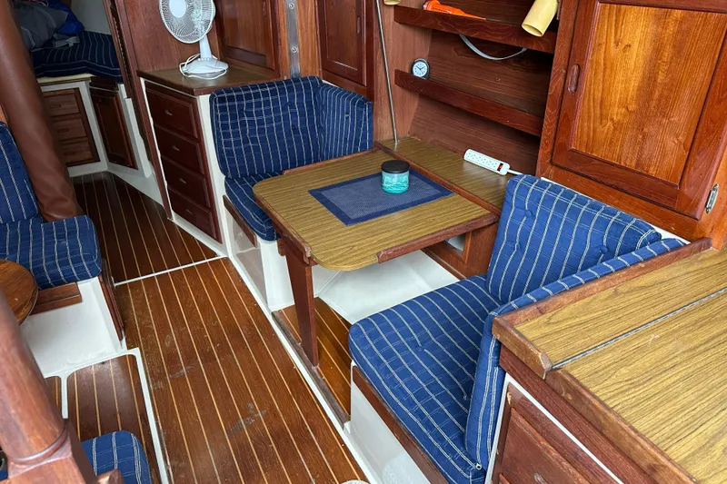 Slide: The Image of Interior of a 1985 Catalina 36 sailboat with wood finish and blue striped cushions. - 14