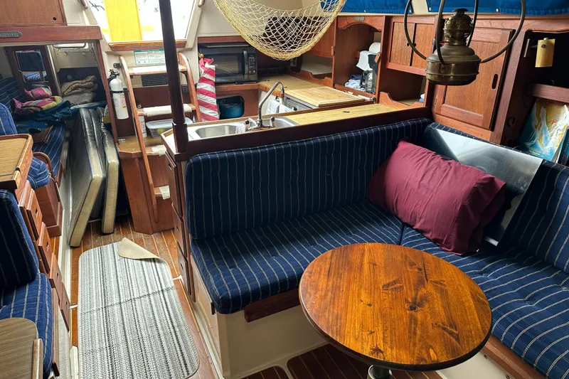Slide: The Image of Interior of a 1985 Catalina 36 sailboat with cozy seating and wooden accents. - 15