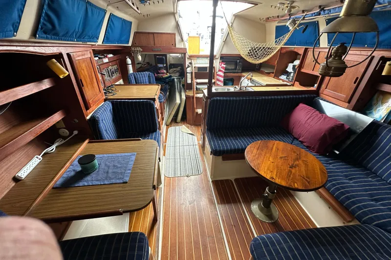 Slide: The Image of Interior of a 1985 Catalina 36 sailboat with cozy seating and wooden furnishings. - 17