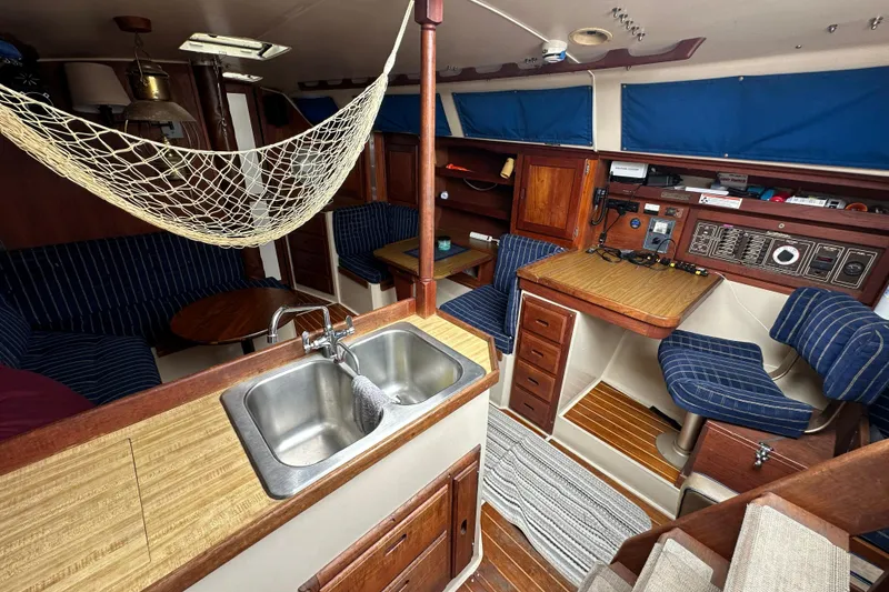 Slide: The Image of Interior of a 1985 Catalina 36 sailboat with wood finishes and blue upholstery. - 18