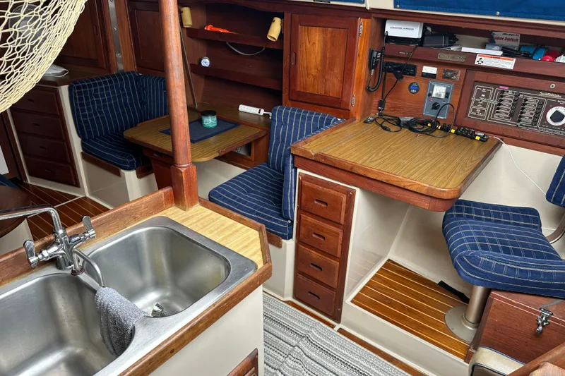 Slide: The Image of Interior of a 1985 Catalina 36 sailboat with wood accents and blue seating. - 19