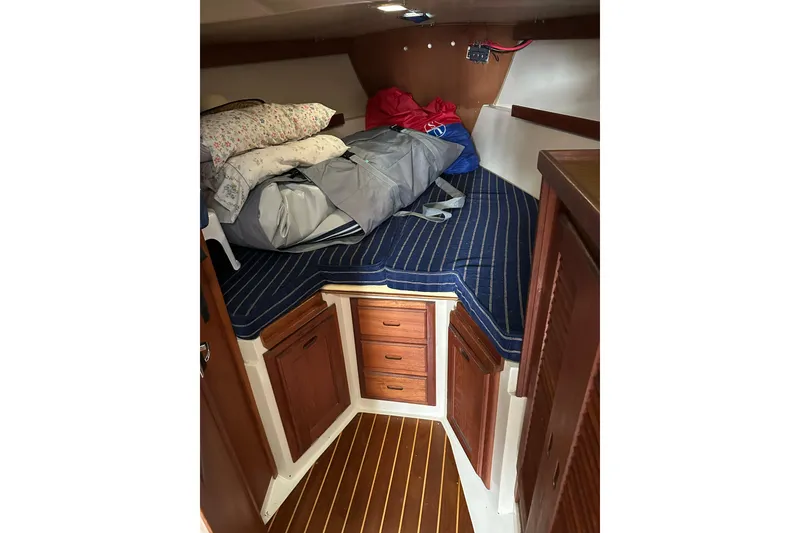 Slide: The Image of Cozy cabin interior of 1985 Catalina 36 sailboat with wooden cabinetry and striped bedding. - 23