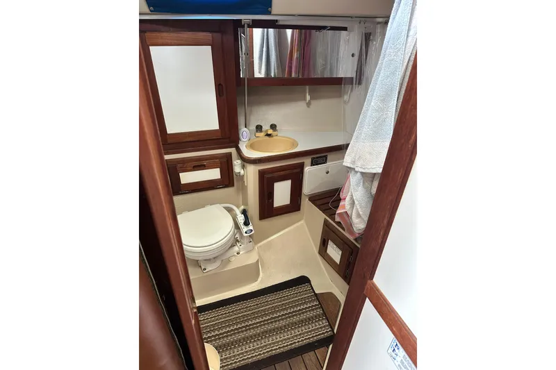 Slide: The Image of 1985 Catalina 36 yacht bathroom with wooden accents, sink, and toilet. - 25