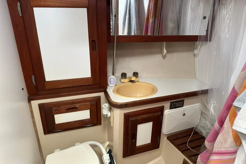 Slide: The Image of 1985 Catalina 36 yacht bathroom with wooden cabinets, sink, and toilet. - 26