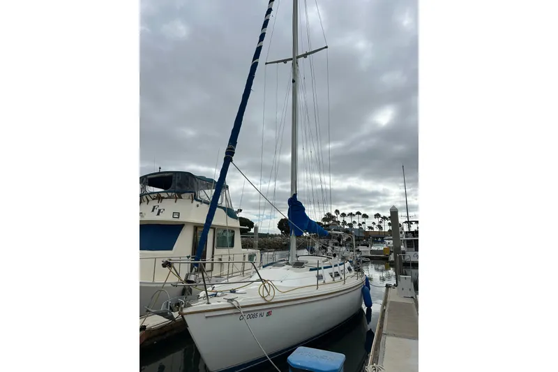 Slide: The Image of 1985 Catalina 36 sailboat docked at marina under cloudy sky. - 32