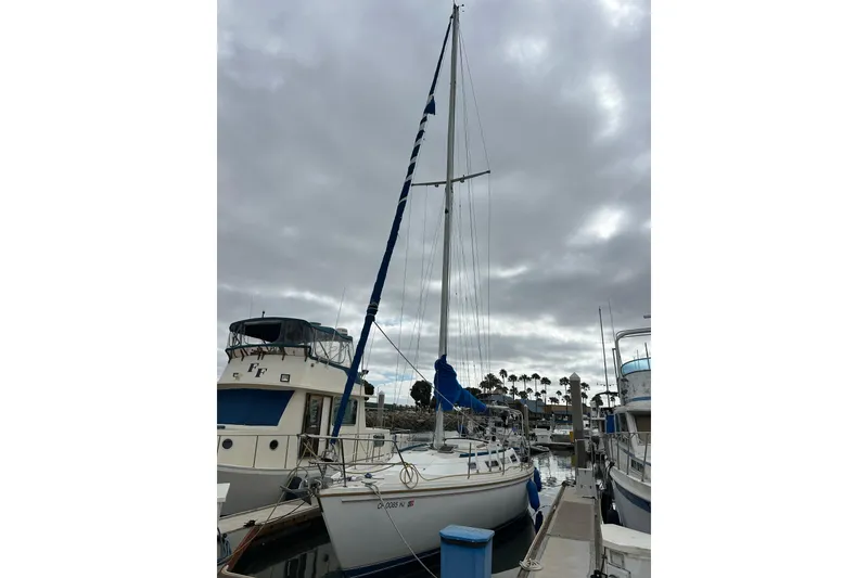 Slide: The Image of 1985 Catalina 36 sailboat docked at marina under cloudy sky. - 33