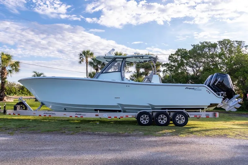 Slide: The Image of 2024 Front Runner 36 Center Console boat on trailer, parked outdoors under a blue sky. - 11