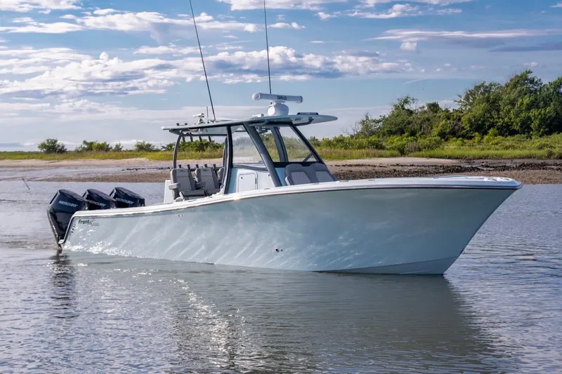 Slide: The Image of 2024 Front Runner 36 Center Console boat cruising on calm water under a clear sky. - 3