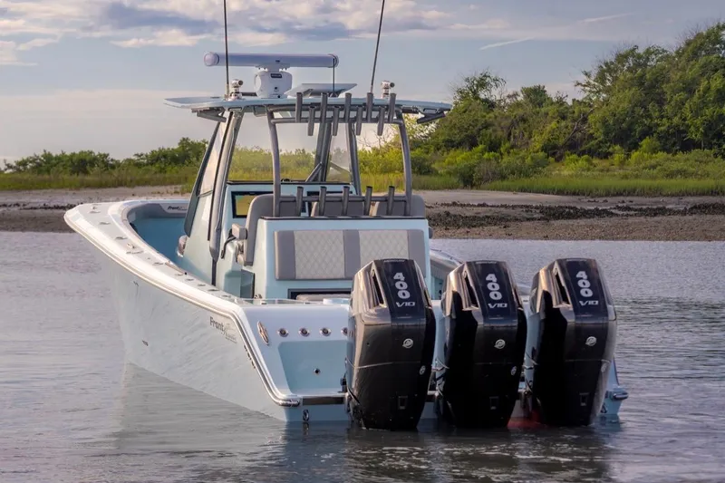 Slide: The Image of 2024 Front Runner 36 Center Console boat with triple 400 V10 engines in serene waters. - 5