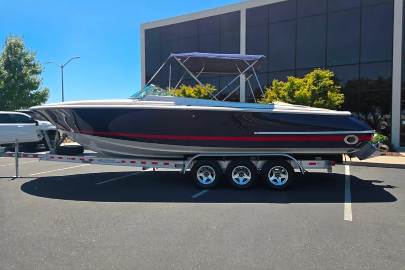 The Image of 2002 Chris-Craft Launch 28 GT I/O boat on trailer, parked outdoors. - 1