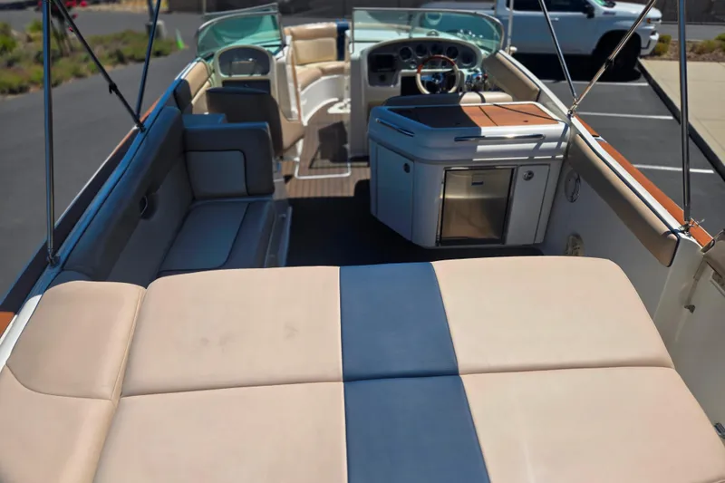 Slide: The Image of 2002 Chris-Craft Launch 28 GT I/O boat interior with seating and helm, parked in a lot. - 24