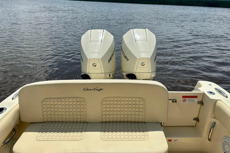 Slide: The Image of 2020 Chris-Craft Catalina 27 boat with twin Mercury engines on a calm lake. - 19