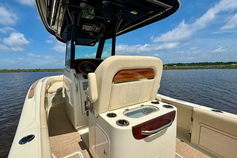 Slide: The Image of 2020 Chris-Craft Catalina 27 boat interior with helm and seating on a sunny day. - 20