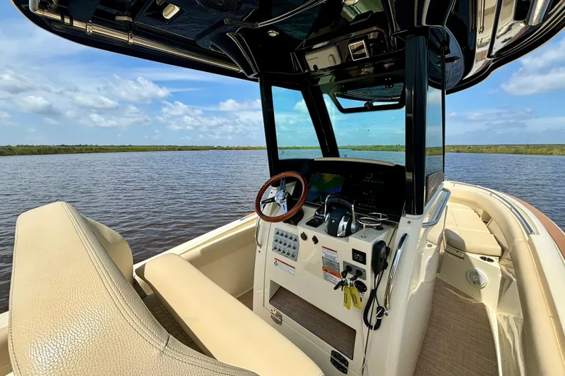 Slide: The Image of 2020 Chris-Craft Catalina 27 boat interior with steering wheel and control panel on calm water. - 22