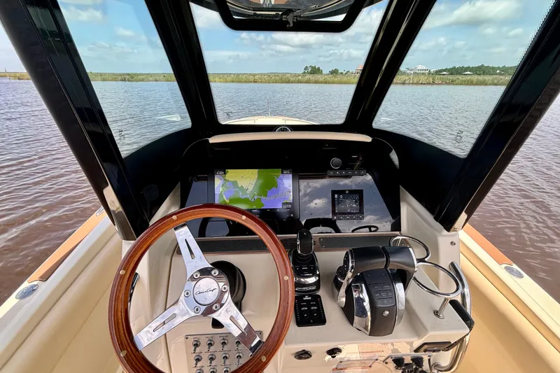 Slide: The Image of 2020 Chris-Craft Catalina 27 helm with navigation display and wooden steering wheel. - 25