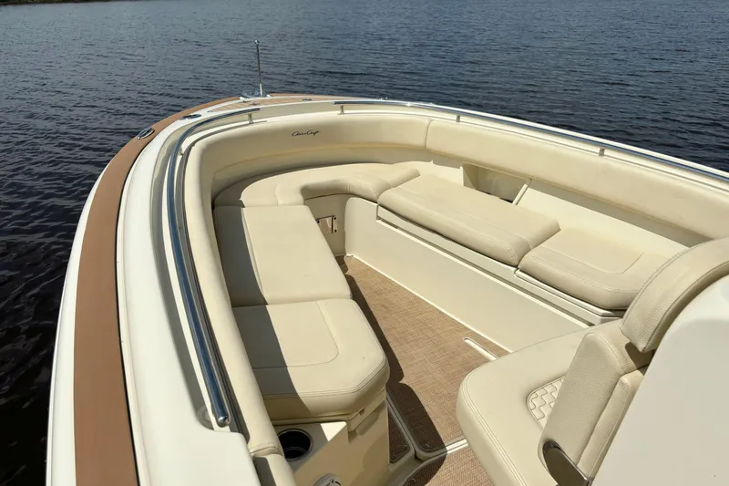 Slide: The Image of 2020 Chris-Craft Catalina 27 boat interior with beige seating, on calm water. - 28