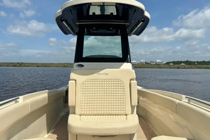 Slide: The Image of 2020 Chris-Craft Catalina 27 boat interior with beige seating on a calm waterway. - 30