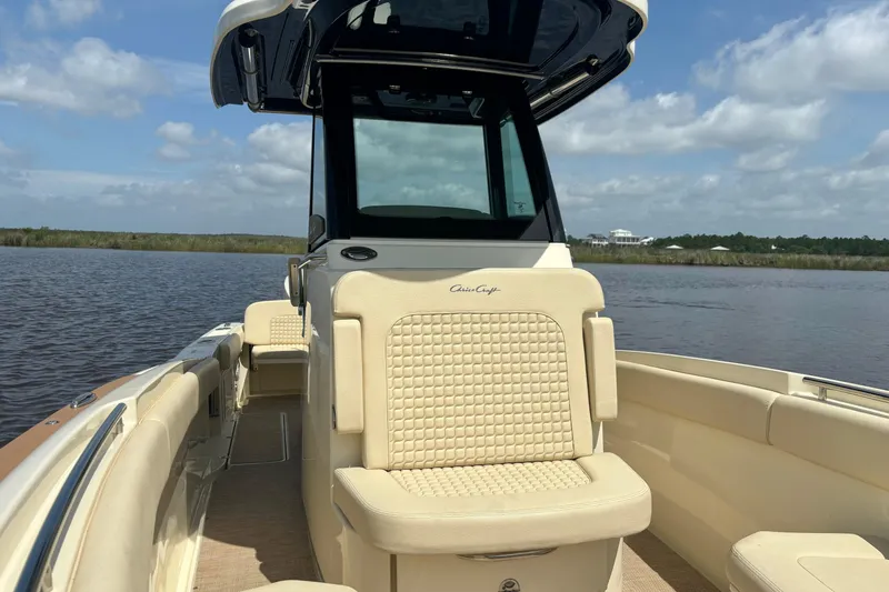 Slide: The Image of 2020 Chris-Craft Catalina 27 boat interior with beige seating on a calm waterway. - 31