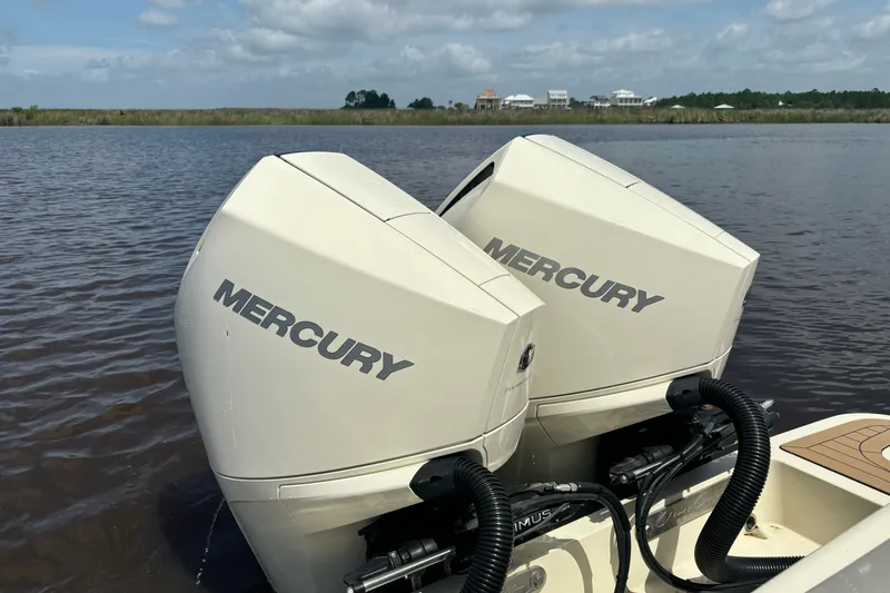 Slide: The Image of Twin Mercury outboard engines on a 2020 Chris-Craft Catalina 27 boat, on a calm waterway. - 34