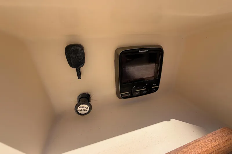 Slide: The Image of 1991 Caliber 33 boat dashboard with Raymarine display and engine stop button. - 24