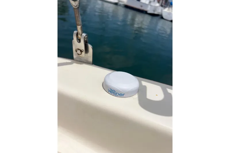 Slide: The Image of White Vesper device on a 1991 Caliber 33 sailboat deck near water. - 19