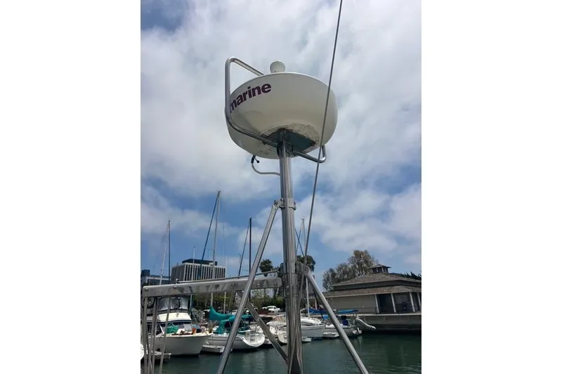 Slide: The Image of Radar equipment on a 1991 Caliber 33 sailboat, docked at a marina under a cloudy sky. - 20