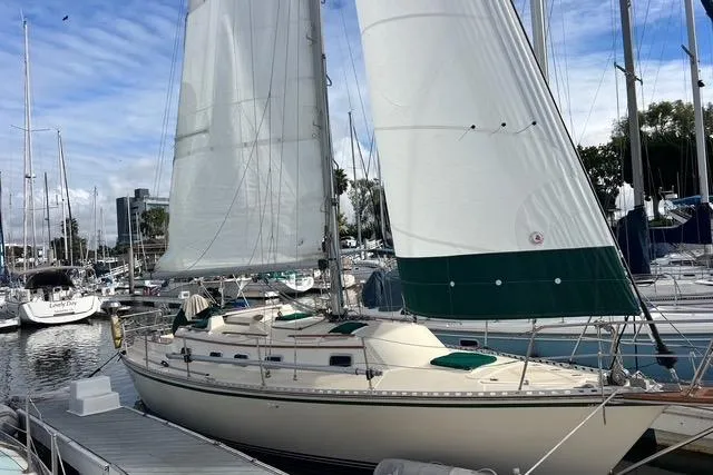 Slide: The Image of Sailboat docked at marina, 1991 Caliber 33 model, with white sails and green accents. - 24