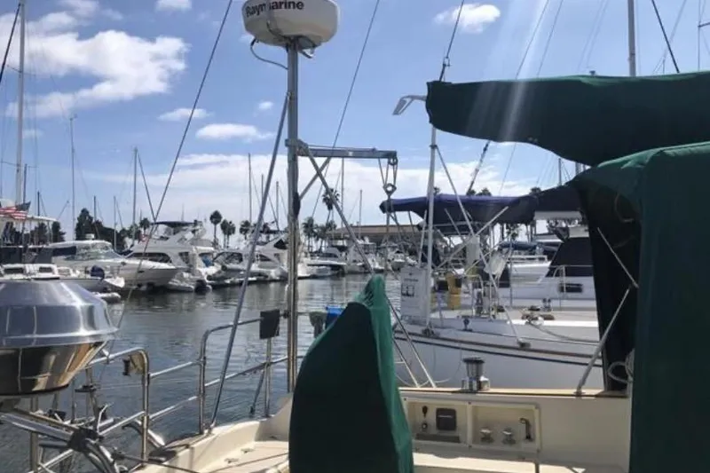Slide: The Image of Marina view with 1991 Caliber 33 sailboat, surrounded by other boats under a blue sky. - 31