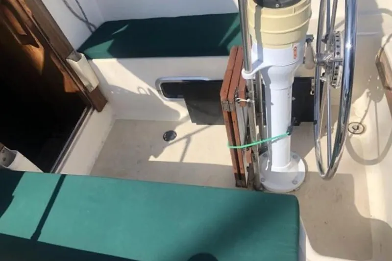 Slide: The Image of 1991 Caliber 33 sailboat cockpit with green cushions and steering wheel. - 37