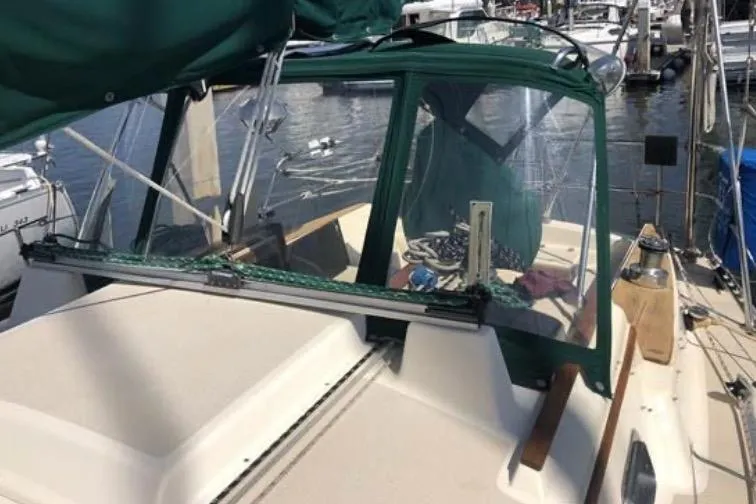 Slide: The Image of 1991 Caliber 33 sailboat cockpit with green canopy, docked at marina. - 38