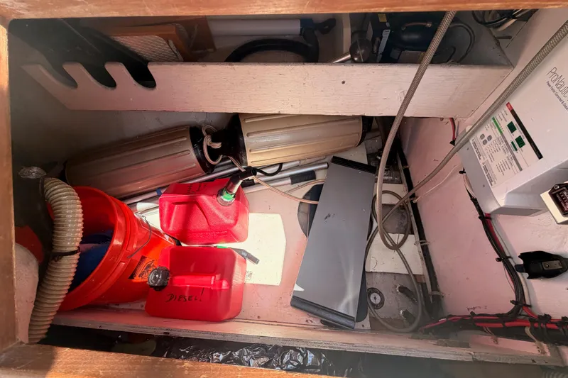 Slide: The Image of Storage compartment in a 1991 Caliber 33 boat with fuel containers and equipment. - 27