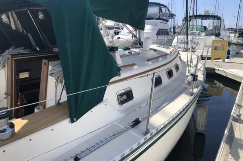 Slide: The Image of 1991 Caliber 33 sailboat docked at marina with green canvas cover. - 39