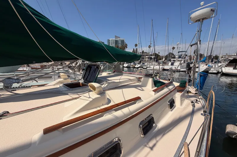 Slide: The Image of 1991 Caliber 33 sailboat docked at marina with green sail cover. - 14