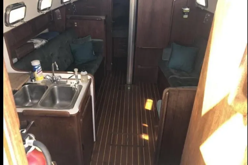 Slide: The Image of Interior of a 1991 Caliber 33 sailboat with wooden finishes and a compact kitchen. - 43