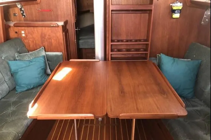 Slide: The Image of Interior of a 1991 Caliber 33 sailboat with wooden table and cushioned seating. - 44
