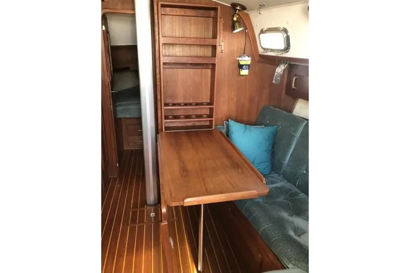 Slide: The Image of Interior of 1991 Caliber 33 sailboat with wooden table and cushioned seating. - 46