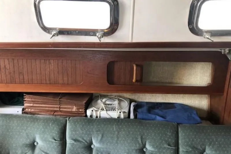 Slide: The Image of Interior of a 1991 Caliber 33 sailboat with wooden shelves and green cushioned seating. - 49