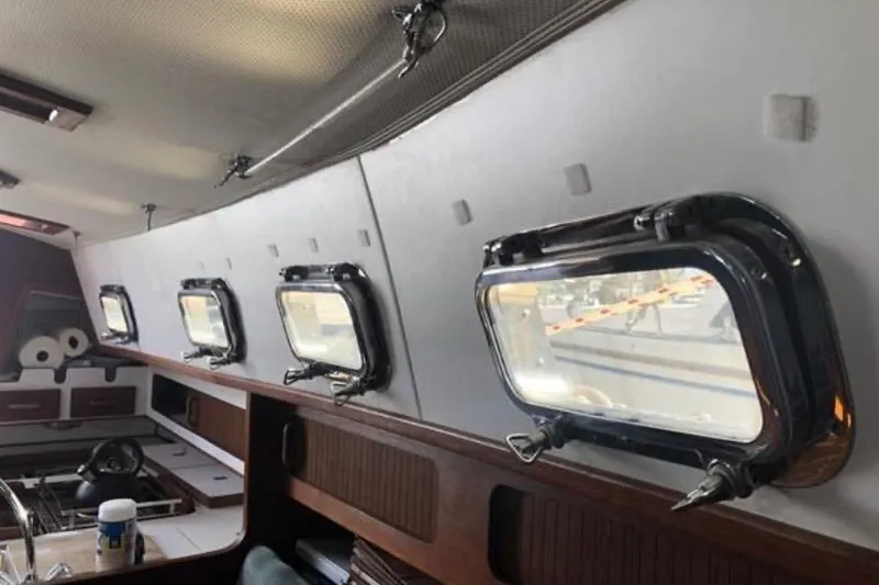 Slide: The Image of Interior of a 1991 Caliber 33 sailboat with portholes and wooden cabinetry. - 51